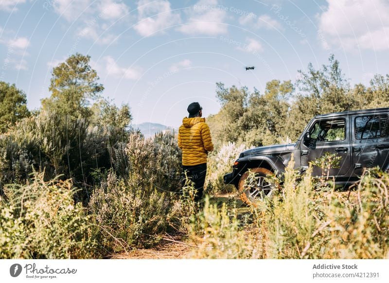 Adventurer flying his drone next to his off-road car on the mountain man sky remote silhouette person technology adventure control discovery sunrise wireless