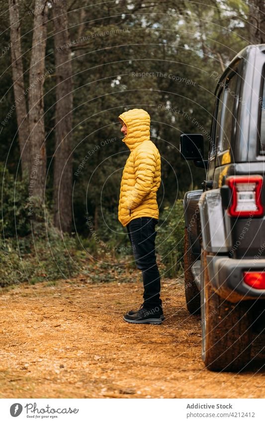 Side view of adventurer next to his off-road car man nature vacation freedom person journey travel transportation lifestyle outdoor vehicle traveler landscape