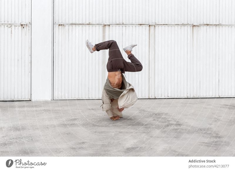 Male break dancer performing on street man hip hop hand hops urban freestyle balance male city move upside down action choreography talent modern motion energy