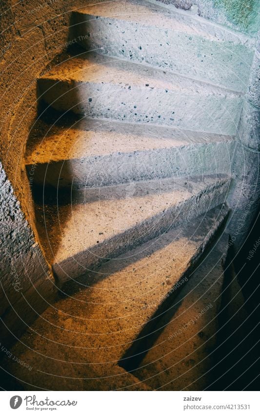 view of a spiral staircase made of old stone step wall castle ancient architecture circle curve down round structure swirl circular stairway vintage