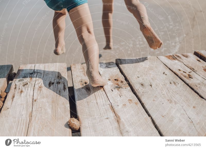 Children jump from the jetty into the water children Infancy Playing Joy Nature Beach Happiness Happy Exterior shot Colour photo Vacation & Travel feet Jump