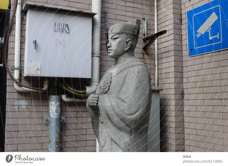 A Chinese statue and video surveillance in Shanghai. Video surveillance China Stone statue Police state Testing & Control Surveillance Statue Guard Monk Signage