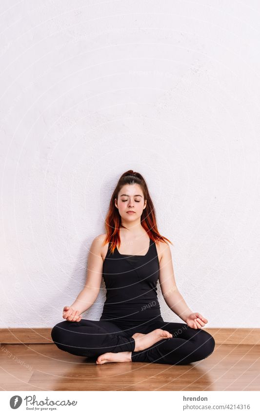 woman practices yoga and meditates in the lotus position meditating meditation exercise relaxation fitness pose mind peace wellness peaceful young adult freedom