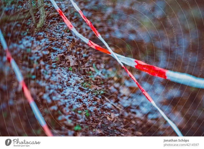 Barrier tape at the edge of the forest barrier tape police cordoning off blocking Crime scene interdiction Band White Red Forest Winter Snow Ground Safety