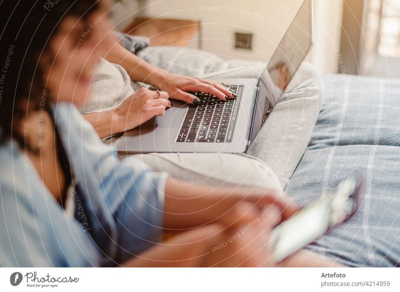 Close up of female hands typing on laptop keyboard at home near his unrecognizable girlfriend. Business, working from home, studying online concept. closeup