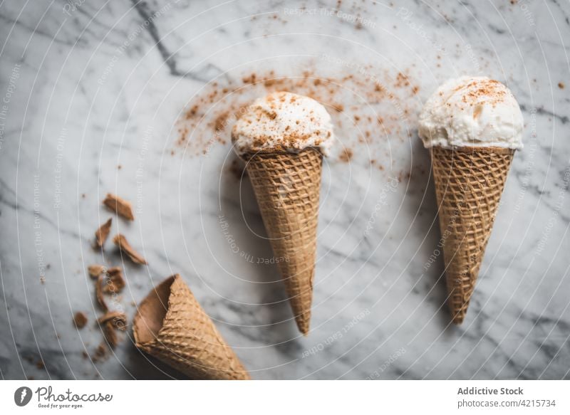 Delicious ice cream cones with cinnamon powder dessert treat sweet waffle meringue milk yummy tasty scoop gelato portion crunchy delicious table marble material