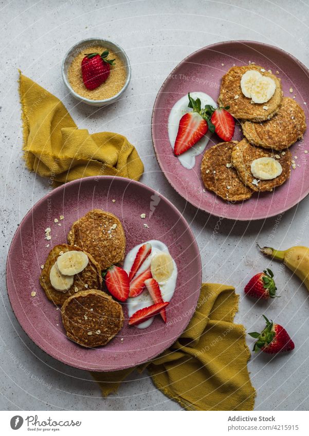 Plate with banana pancakes and a few pieces of strawberries dessert sweet breakfast food strawberry sugar cream homemade american delicious plate meal tasty