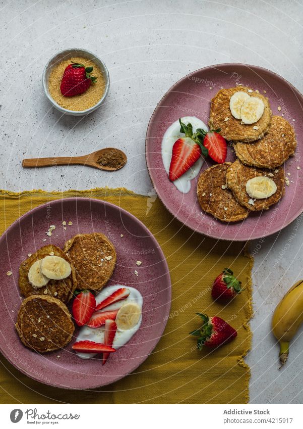 Plate with banana pancakes and a few pieces of strawberries dessert sweet breakfast food strawberry sugar cream homemade american delicious plate meal tasty