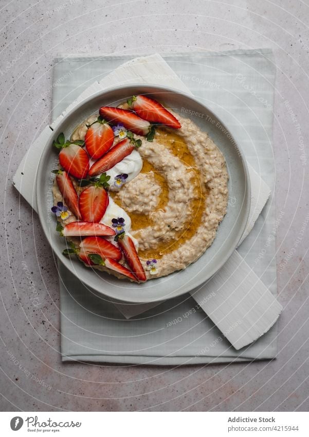 Closeup of a delicious plate of strawberry porridge food oatmeal breakfast healthy fruit cereal bowl granola snack white sweet vegetarian table flakes nutrition