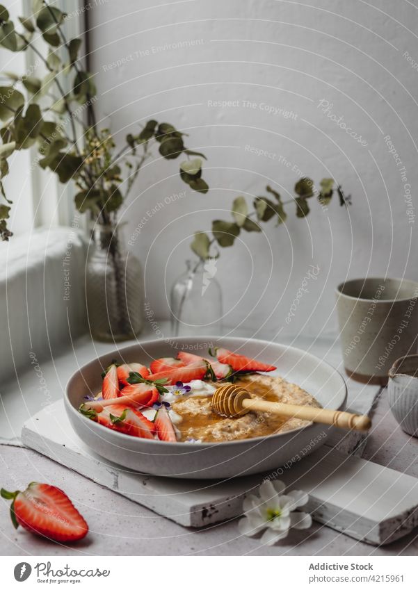 Closeup of a delicious plate of strawberry porridge food oatmeal breakfast healthy fruit cereal bowl morning granola diet snack white sweet vegetarian table