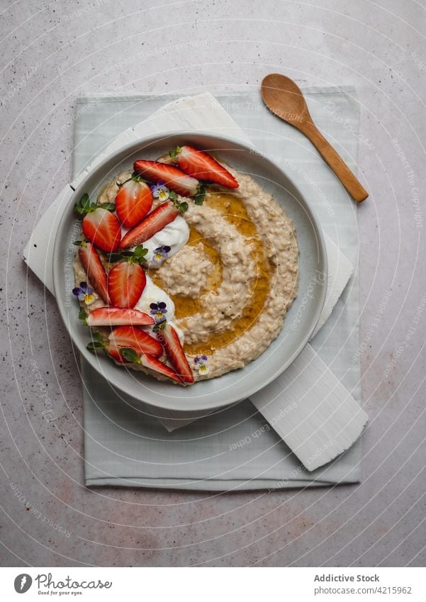 Closeup of a delicious plate of strawberry porridge food oatmeal breakfast healthy fruit cereal bowl granola snack white sweet vegetarian table flakes nutrition