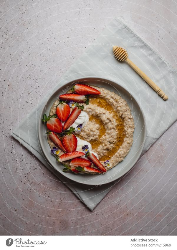 Closeup of a delicious plate of strawberry porridge food oatmeal breakfast healthy fruit cereal bowl granola snack white sweet vegetarian table flakes nutrition