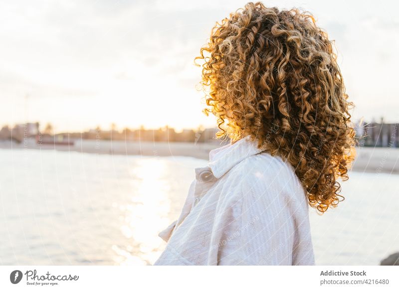 Unrecognizable ethnic woman enjoying sunset on seashore admire summer city sundown freedom female relax nature seaside peaceful lifestyle calm holiday tranquil