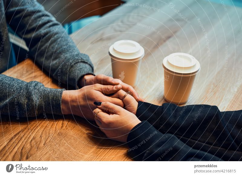 Loving couple holding hands sitting in cafe  drinking coffee man restaurant caucasian indoors shop coffee shop inside hot cup lifestyles espresso mug break