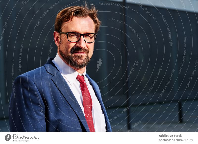 Well dressed businessman with beard on city street executive well dressed independent confident professional masculine building portrait entrepreneur tie suit