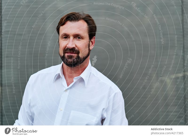 Mature businessman in white shirt on gray background executive masculine virile independent formal friendly sincere portrait well dressed macho style