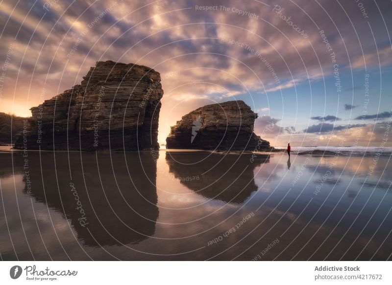 Unrecognizable person standing on beach at sunset rock seashore sundown silhouette evening coast galicia spain as catedrais beach water sky tranquil travel