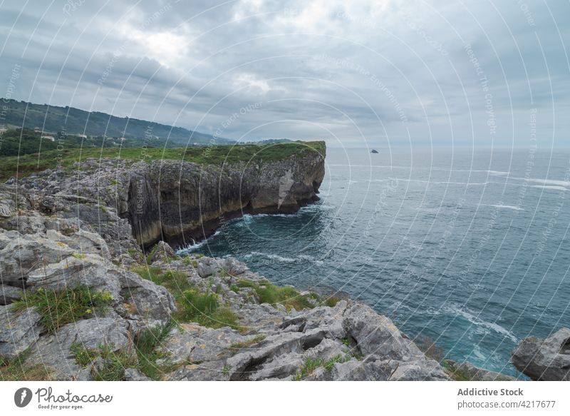 Rocky cliff near sea on cloudy day rocky scenery shore rough coast seascape asturias spain ribadesella coast water seashore geology environment overcast stone