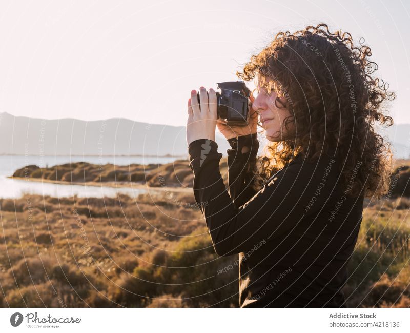 Woman with photo camera on beach woman sea traveler photography nature take female ethnic vacation focus happy tourist holiday positive enjoy take photo shoot