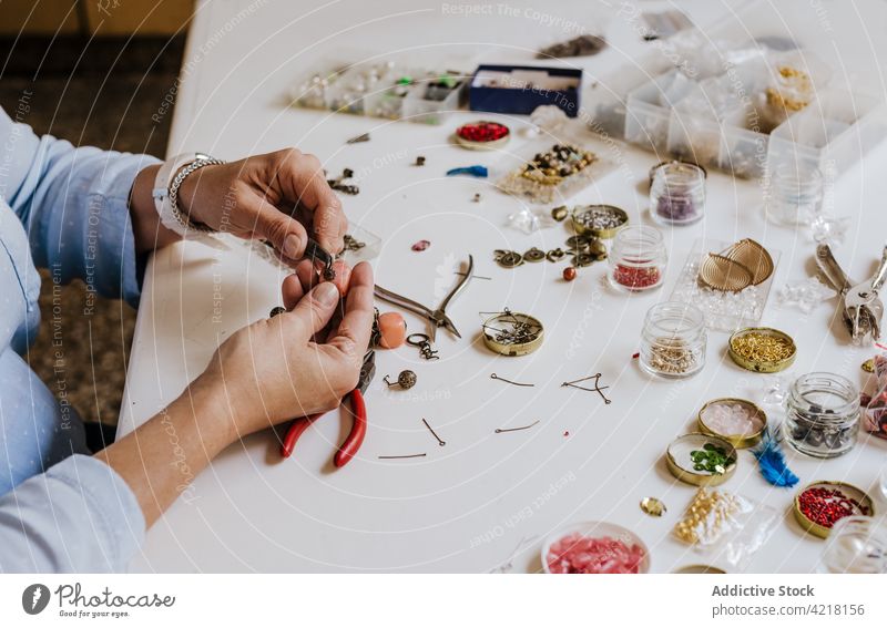 Woman making accessory with natural stones woman artisan necklace skill instrument workshop decorate adorn create female process designer bijouterie pincers