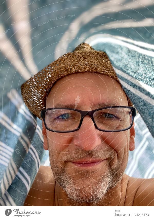 Beach life under a beach towel Man portrait Contentment Adults Looking Straw hat Designer stubble Eyeglasses Person wearing glasses Human being 1