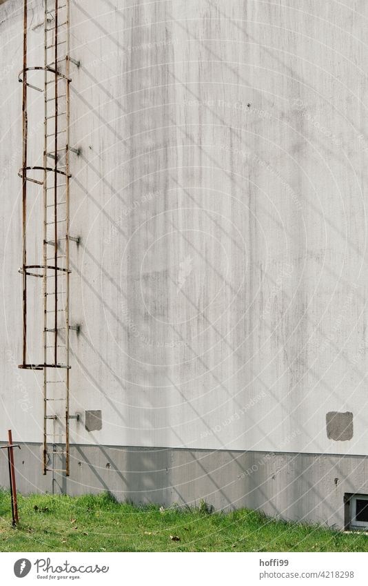 Shadow cast by an external conductor on a grey wall rusty escape ladder Ladder Escape route shadow cast Warehouse Harbour Facade Industry Industrial Photography