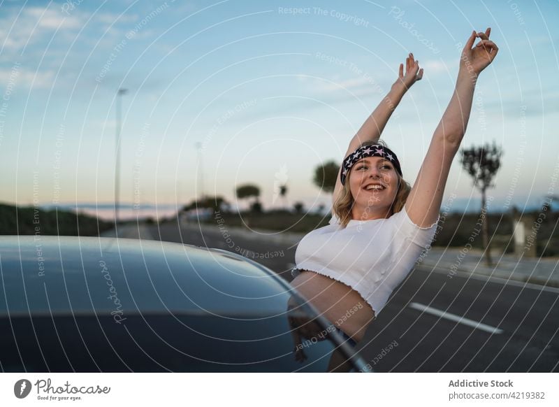 Happy woman enjoying road trip car freedom american happy window travel journey female sunset carefree usa young lifestyle vacation evening traveler arms raised