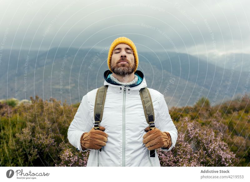 Happy bearded traveling man standing in mountains traveler having fun wanderlust camper cheerful enjoy nature male glad positive happy adventure vacation smile