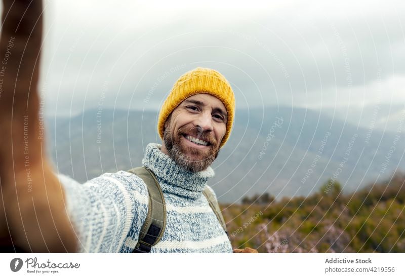 Happy traveler taking selfie in highlands mountain man cheerful adventure wanderlust explore self portrait male vacation happy smile camper hiker enjoy nature