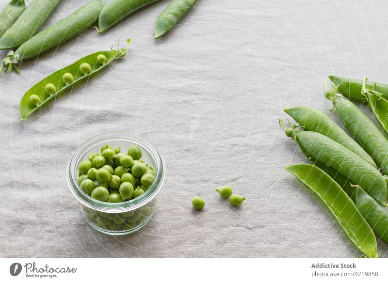 Bowl with heap of pea pods and green peas bowl fresh crunchy vegetarian raw healthy bean nutrient glass crispy uncooked vitamin whole table edible organic