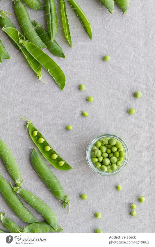 Bowl with heap of pea pods and green peas bowl fresh crunchy vegetarian raw healthy bean nutrient glass crispy uncooked vitamin whole table edible organic