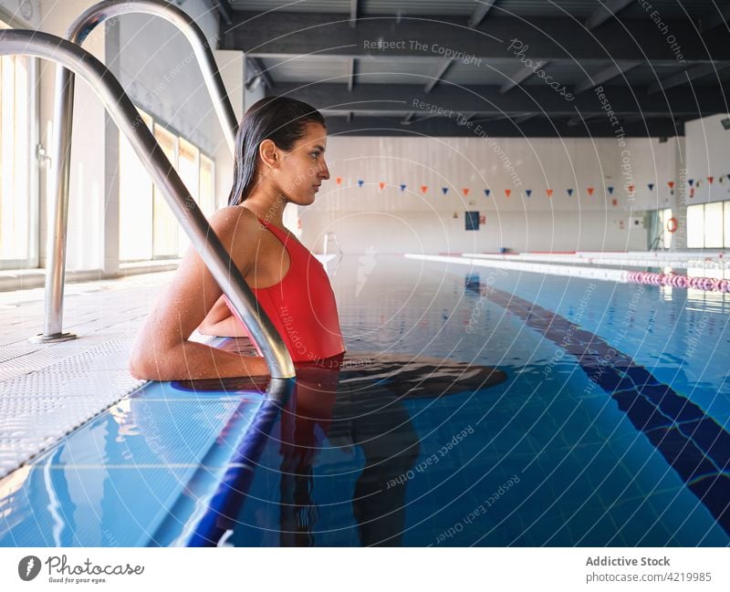 Sportswoman in swimsuit resting in swimming pool sportswoman swimwear feminine tender pure idyllic alone body romantic gentle charming pleasant color blue