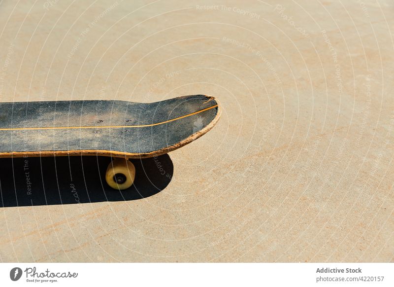 Close-up of a worn skateboard on concrete paving skating skatepark closeup outdoors light style sunset recreational road action sport balance urban street city