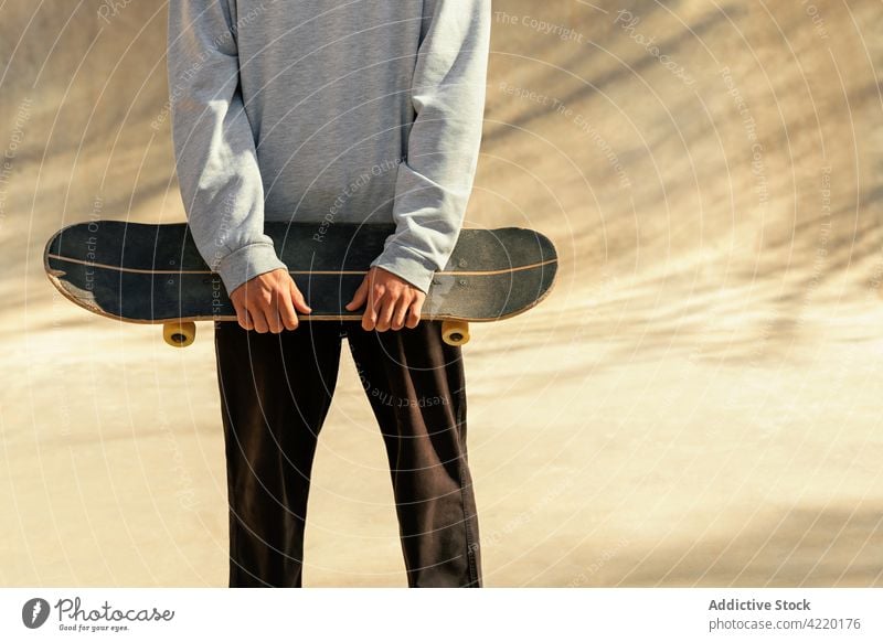 Crop of a man holding his skateboard Young skating unrecognizable skatepark portrait lifestyle people asphalt shadow summer recreation street leisure adult