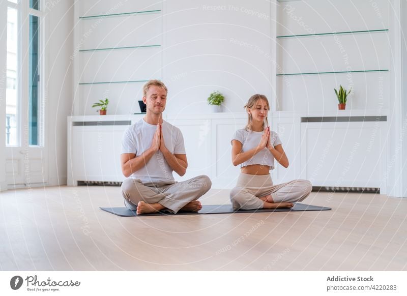 Calm couple meditating together on mat at home meditate yoga lotus pose zen calm prayer hands harmony practice eyes closed vitality asana relax serene spirit