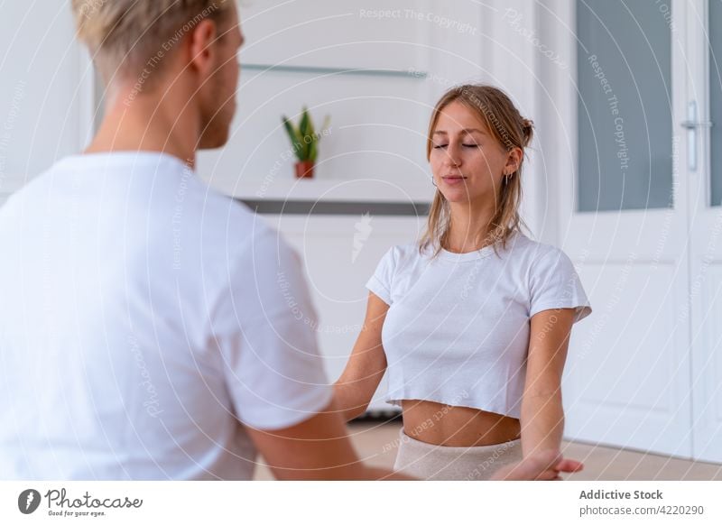 Calm couple meditating together on mat at home meditate yoga lotus pose zen holding hands calm harmony practice eyes closed vitality asana relax serene spirit