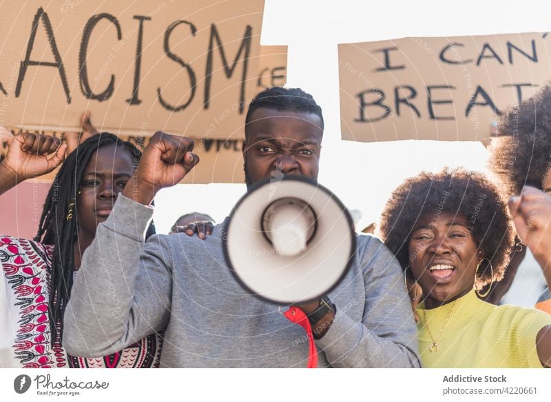 Black man protesting with megaphone in street black lives matter crowd people racism discriminate activist protester loudspeaker blm multiracial multiethnic