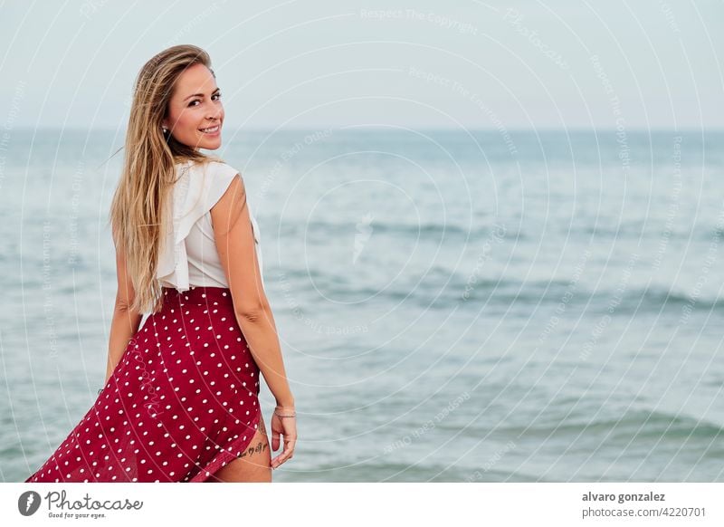 young woman alone in front of the sea in a cloudy summer day beach ocean girl sky beautiful clouds season water vacation beauty female hat relax people travel