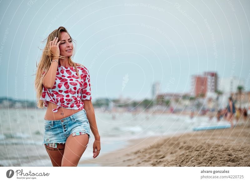 young woman at the beach on a summer day sea water ocean girl female sky beautiful cloudy hat sand travel vacation beauty nature coast people lifestyle happy