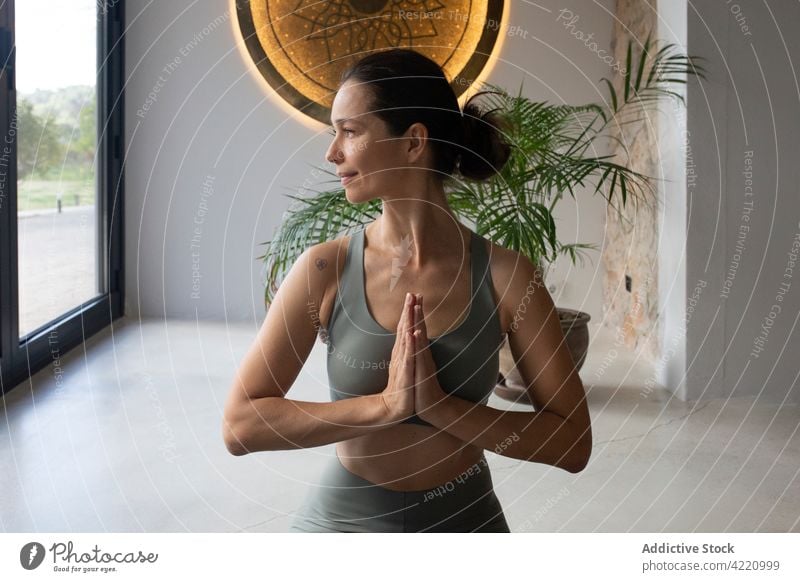 Fit woman meditating at home meditate yoga sunlight namaste prayer asana pose practice female healthy wellness vitality gesture harmony zen tranquil spirit