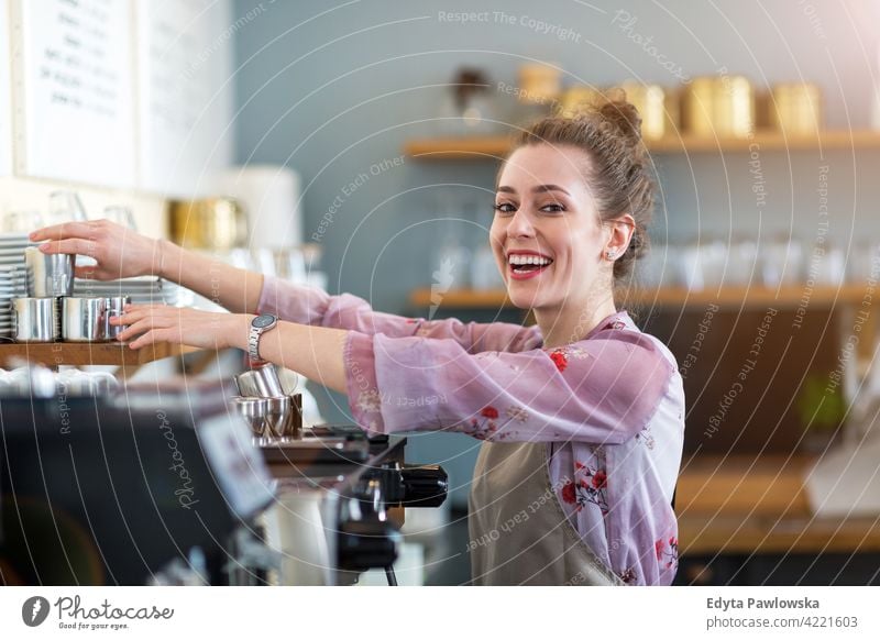 Young woman working in coffee shop people young adult casual attractive female smiling happy indoors Caucasian toothy enjoying cafe restaurant apron business