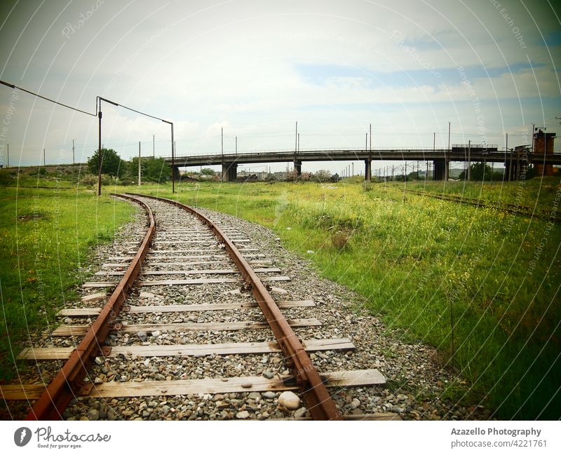 An old railway and a bridge with lomography effect railroad metal iron wood stone pebble gravel green grass transportation vintage retro train wagon carriage