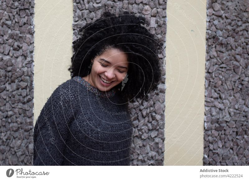 Happy ethnic woman with curly hair in city afro hairstyle smile charming appearance beauty natural female cheerful young happy glad street optimist delight joy