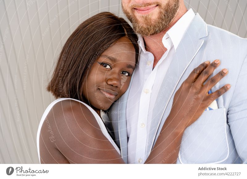 Smiling multiracial couple embracing on street cheerful relationship embrace hug smile romantic elegant love tender cuddle happy together sidewalk positive