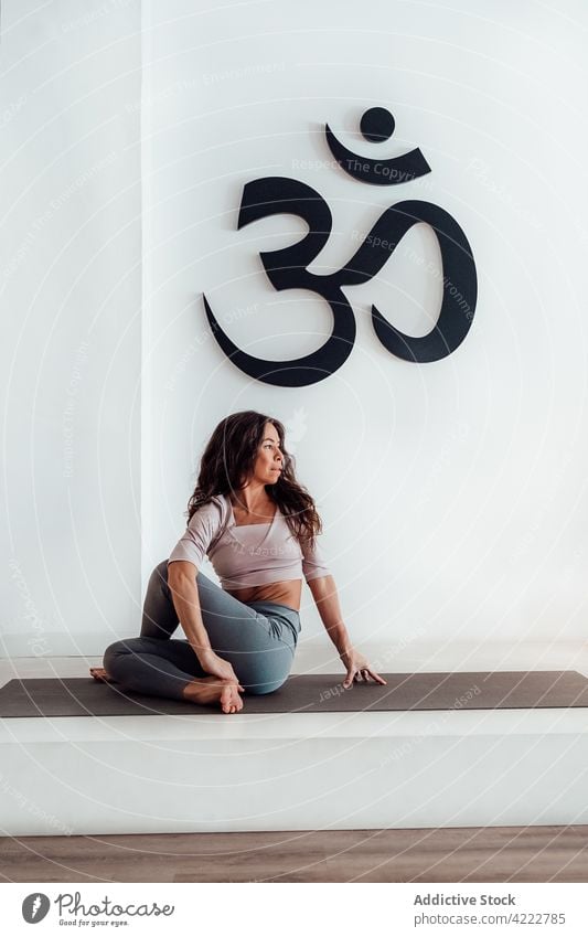 Serene woman doing yoga in Lord of the Fishes pose lord of the fishes pose flexible stretch matsyendrasana studio practice female healthy calm stress relief