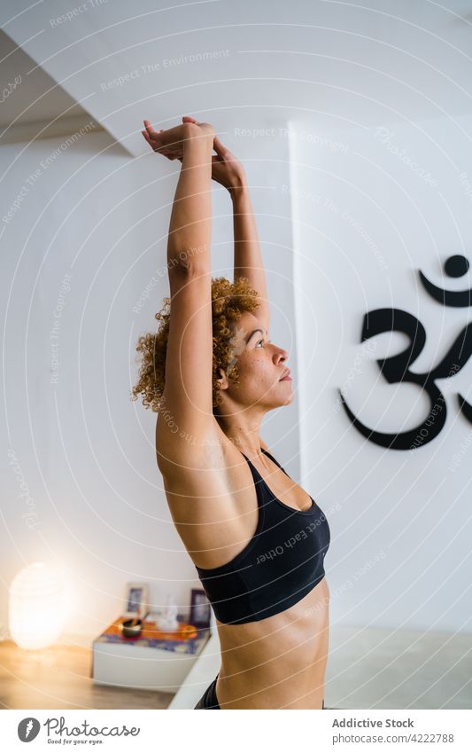 Ethnic woman doing yoga in Mountain pose in studio mountain pose practice stretch tranquil asana peaceful female ethnic calm afro hairstyle urdhva hastasana