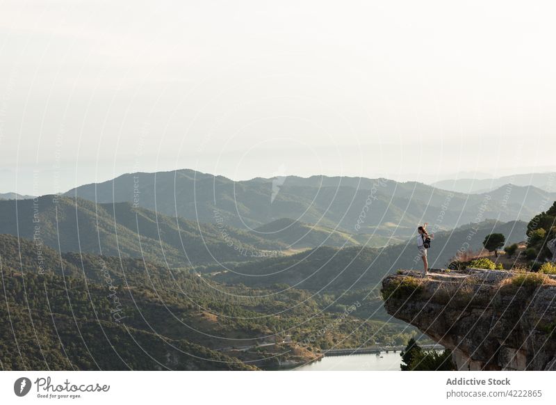 Carefree traveling woman standing on edge of cliff traveler freedom mountain outstretch carefree enjoy viewpoint highland adventure female hiker trekking hill