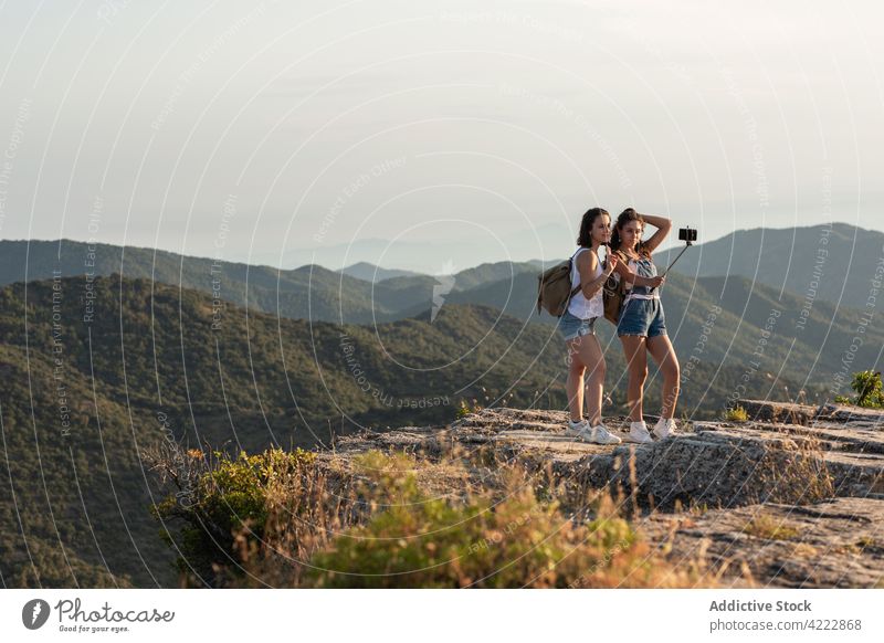 Traveling women taking selfie in mountains travel smartphone selfie stick highland hike trekking memory female together nature friend adventure summer backpack