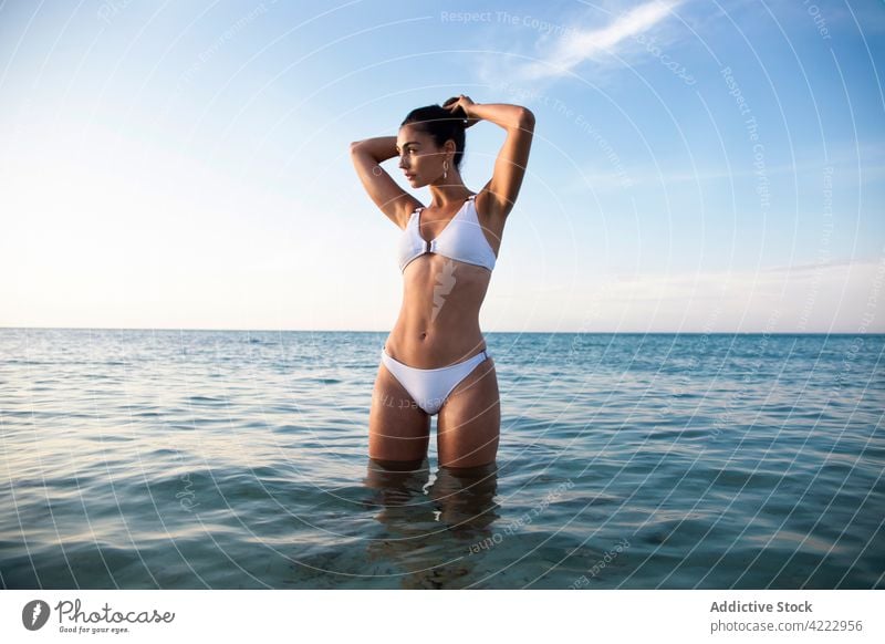 Model in swimsuit inside water on the beach model sea body swimwear feminine confident seascape woman blue sky attractive nature cloudy gentle ocean summer