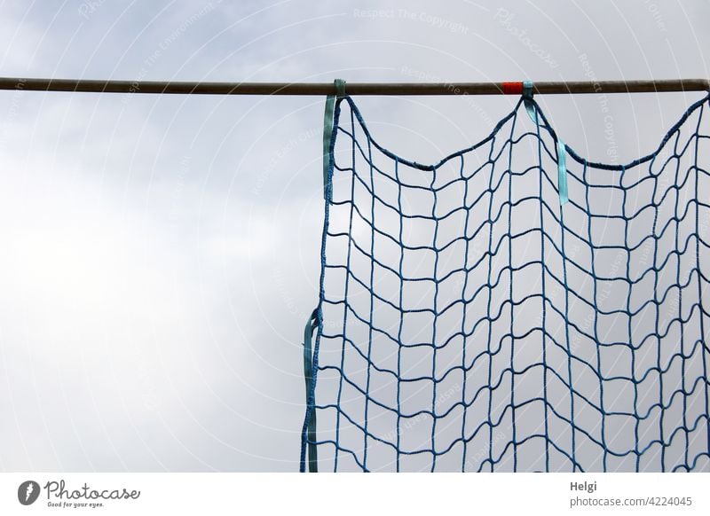 safety net pushed to the side for protection on a construction site in front of a blue-grey sky Net Network Backup Construction site pole Metal Metal post Sky